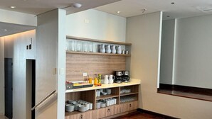 Une cuisine moderne dotée d’étagères intégrées, d’un réfrigérateur et d’une machine à café.