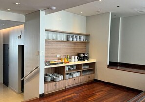 Una cocina moderna con estantes empotrados, un refrigerador y una cafetera.