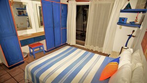 A bedroom with a bed, a bench, a wardrobe, and a mirror. - Apartment Luna Antigua 2 BR 1 Bth (Playa del Carmen)