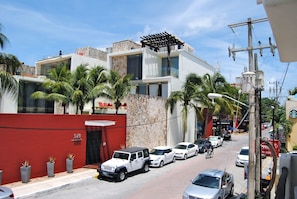 A modern building with a stone facade, a red wall, and a sign indicating it is a condominium. - Apartment Luna Antigua 2 BR 1 Bth (Playa del Carmen)