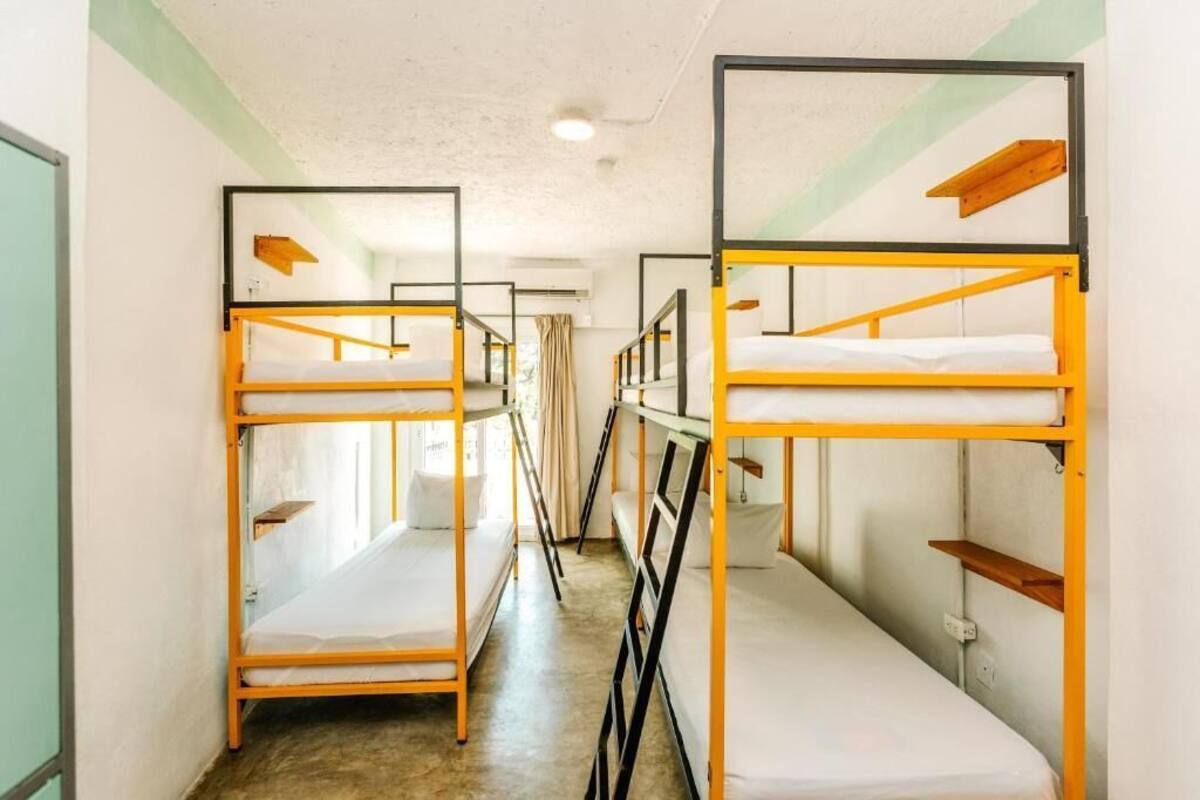 Ein Korridor mit Etagenbetten, jedes mit einem Holzboden und einer Matratze.