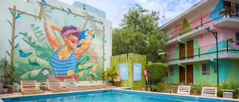 Alberca al aire libre y camastros