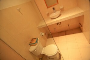 A bathroom with a toilet, sink, and mirror. - Apartment 1 Bedroom Tohoku (Playa del Carmen)