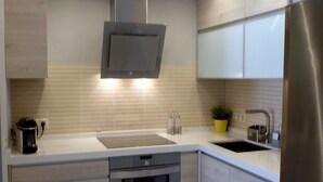 Een moderne keuken met een ingebouwde oven, roestvrijstalen apparatuur en een spoelbak.