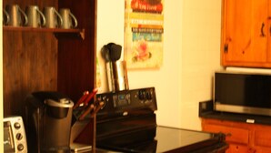 Una cocina con armarios de madera, una estufa y un microondas.
