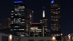 A rooftop pool with a cityscape view at night. - King Deluxe Apartments (Melbourne)
