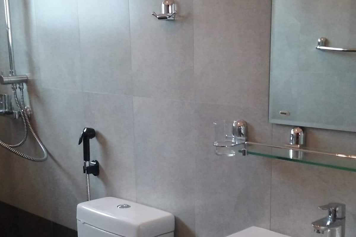 Une salle de bain moderne équipée de toilettes, d’un bidet et d’un lavabo.