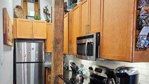 Una cocina moderna con armarios de madera, electrodomésticos de acero inoxidable y una encimera negra.