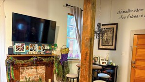 Una sala de estar acogedora con chimenea, un televisor de pantalla plana y una zona de bar con taburetes.