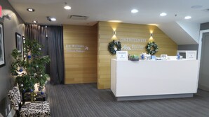Ein Empfangsbereich mit einer Rezeption, einem Weihnachtsbaum und einem Schild für One Wellness Fitness Studio und Maniküre/Pediküre.