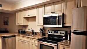 A kitchen with white cabinets, a microwave, a stove, and a dishwasher.