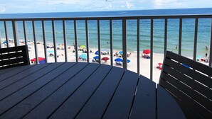 A wooden deck with a view of a beach and ocean.