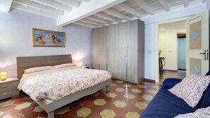 A bedroom with a bed, a nightstand, a wardrobe, and a door leading to another room. - PF Apartment 2 Bedroom- and you're in Piazza Navona CIN:IT058091C2SLMC5MBC (Roma)