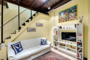 Relax in this inviting living room with a sofa, flat-screen TV, and vibrant artwork.