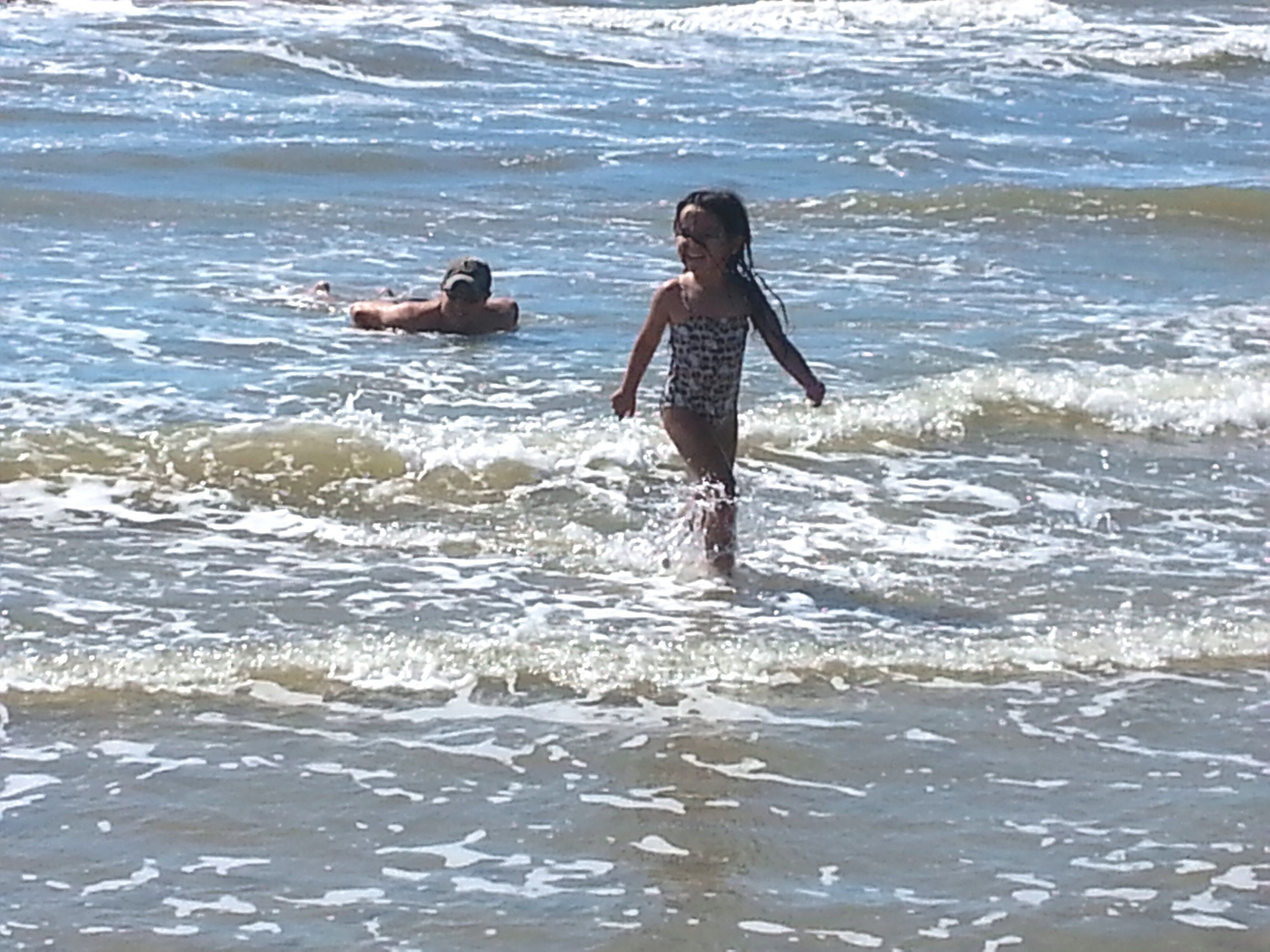 Escena de playa con agua cristalina y olas.