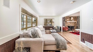 A modern living room with a sofa, a fireplace, and a stone wall.