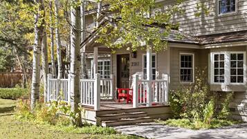 A two-story house with a porch, a red chair, and a mailbox marked "3780".