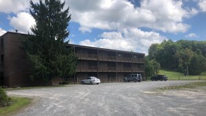 A multi-story building with a parking area in front. - Winterplace Condo D303 (Ghent)