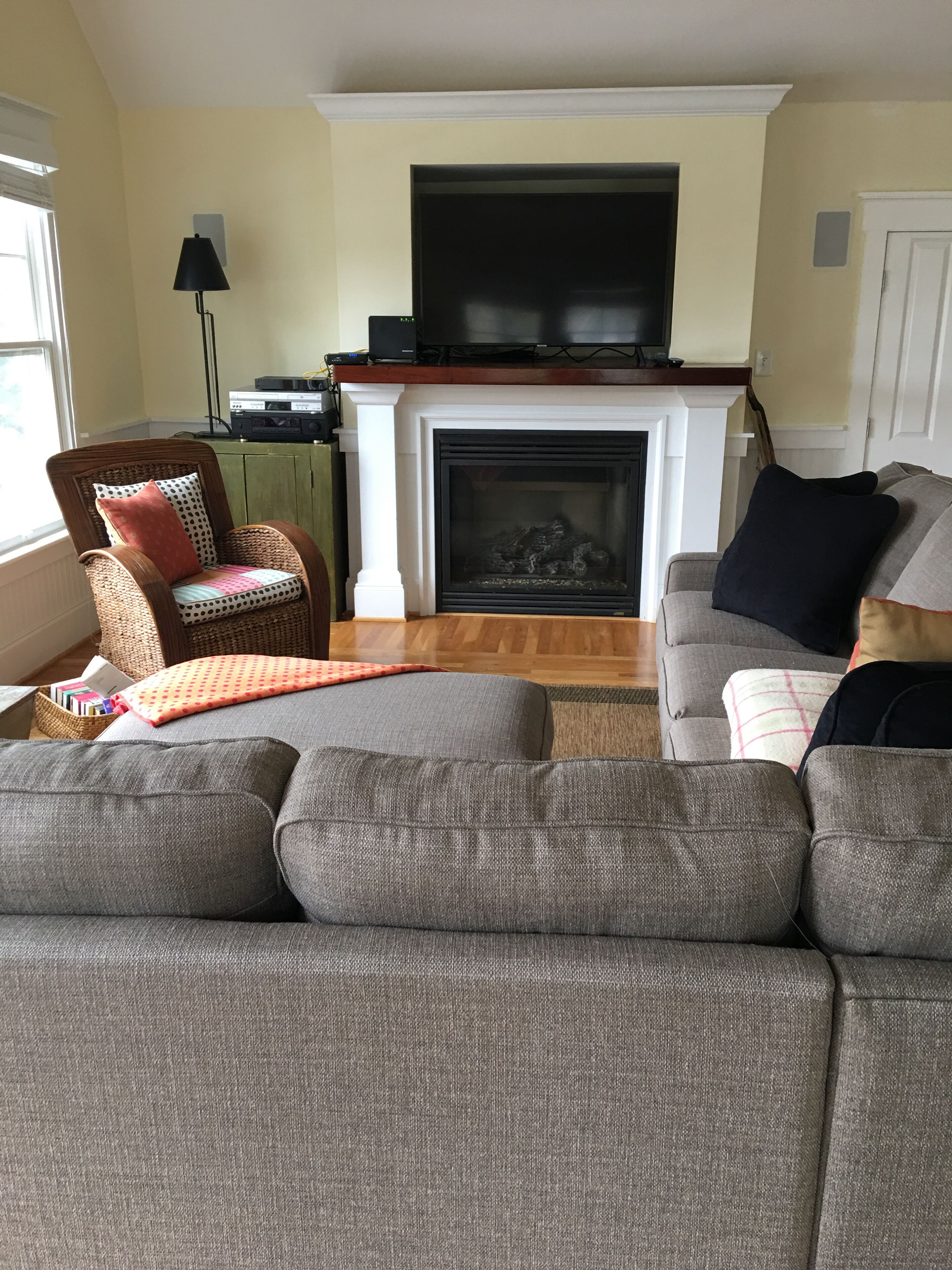 A living room with a fireplace, a television, a sofa, and a chair.