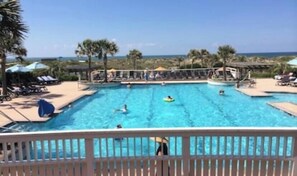 A large outdoor swimming pool with multiple lanes, surrounded by palm trees and a clear sky. - Great Home with All Amenities feel free to inquire monthly rental, Dec, to Feb  (BALDHEAD ISLAND)