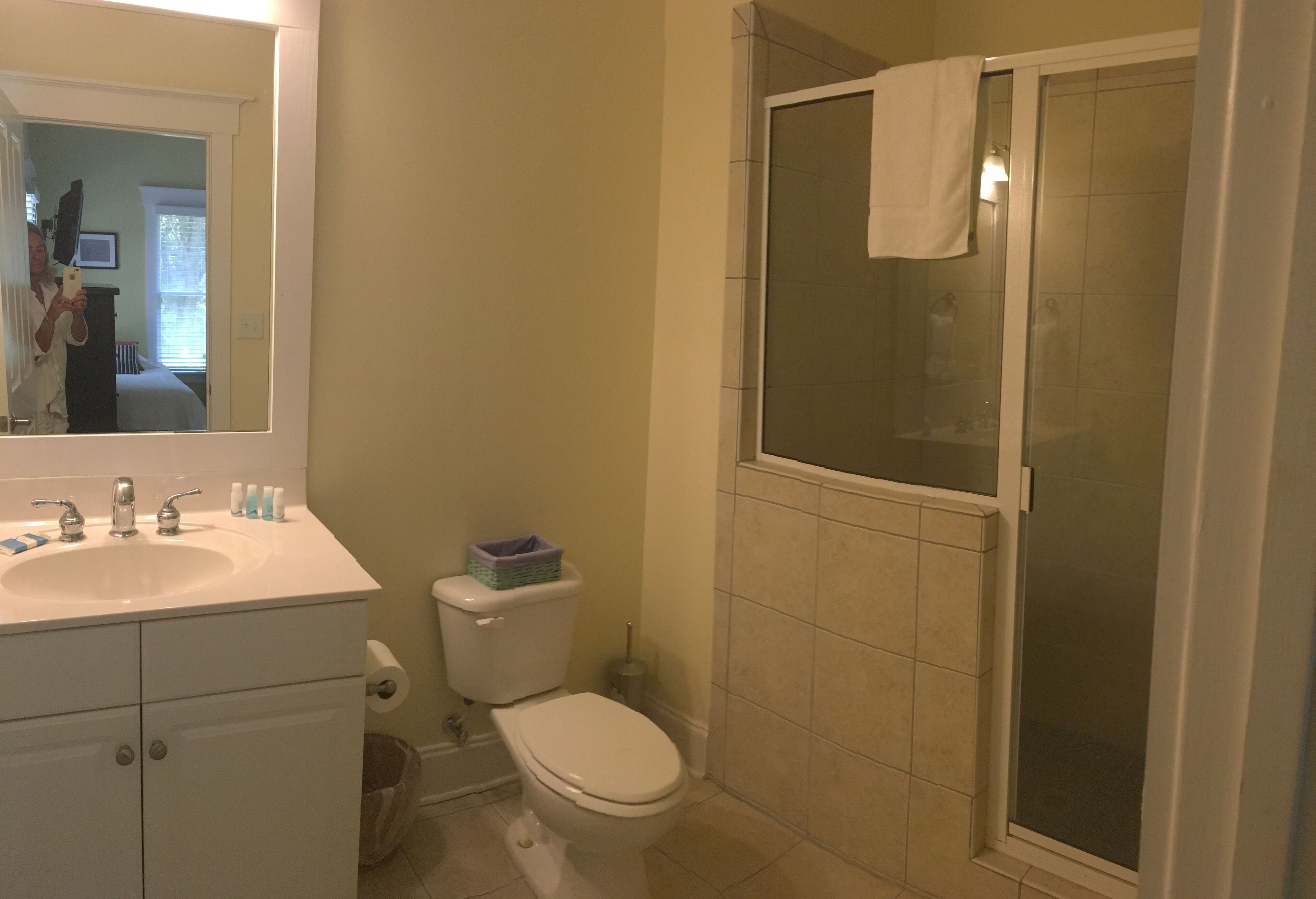 A bathroom with a sink, toilet, and a glass-enclosed shower area.