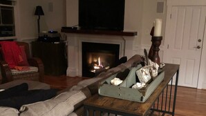 A living room with a fireplace, a television, and a sofa.