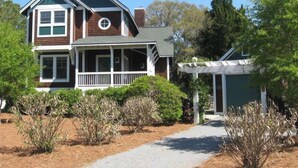 A two-story house with a porch, a garage, and a well-maintained garden.