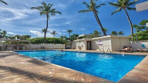 A swimming pool with palm trees, a lifeguard tower, and lounge chairs. - Steps to beach! Beautiful renovated 1 bedroom (Kihei)