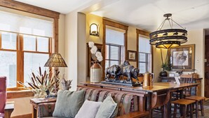 Een gezellige woonkamer met een houten bank, een bijzettafeltje en een kroonluchter.