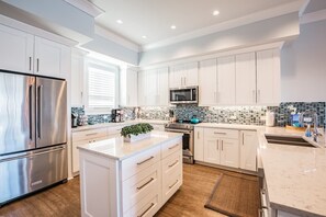 Enjoy cooking in this well-lit kitchen with a refrigerator, oven, and ample storage.
