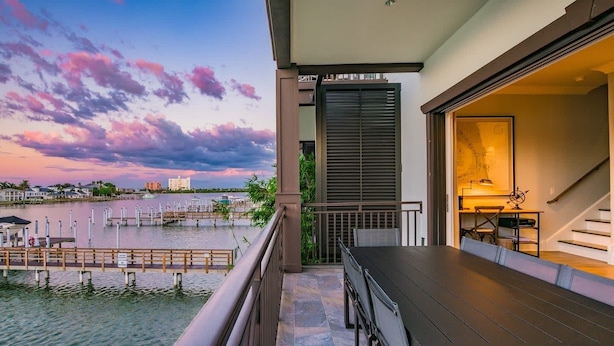 Ein Balkon mit Blick auf eine Marina und einen Sonnenuntergang.