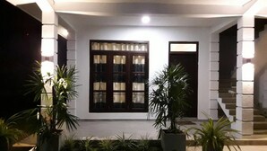 A modern house with a well-lit entrance, a staircase, and potted plants. - Airport Grand Holiday Home (Seeduwa - Katunayake)