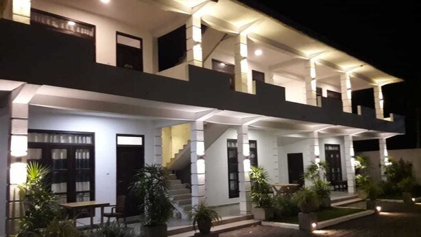 A two-story building with a covered porch, multiple doors, and potted plants. - Airport Grand Holiday Home (Seeduwa - Katunayake)