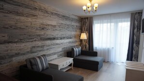 Una sala de estar moderna con una pared de madera, dos sofás, una mesita y una lámpara.