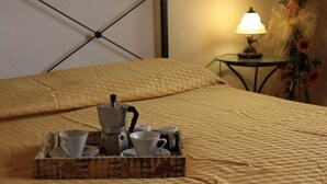 Ein Bett mit Tablett, Kaffeetassen, einer Lampe und einer Blumendekoration.