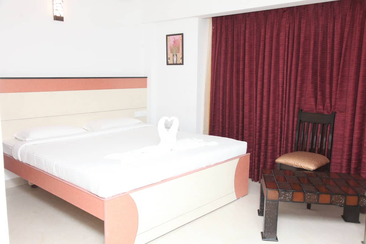 Una habitación de hotel con una cama, un banco y una silla.
