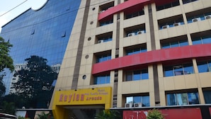 A hotel with a yellow sign, multiple floors, and a modern design. - Hotel Sai Leela Grand (Mumbai)