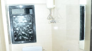 A small bathroom with a toilet, sink, and shower. - Hotel Sai Leela Grand (Mumbai)