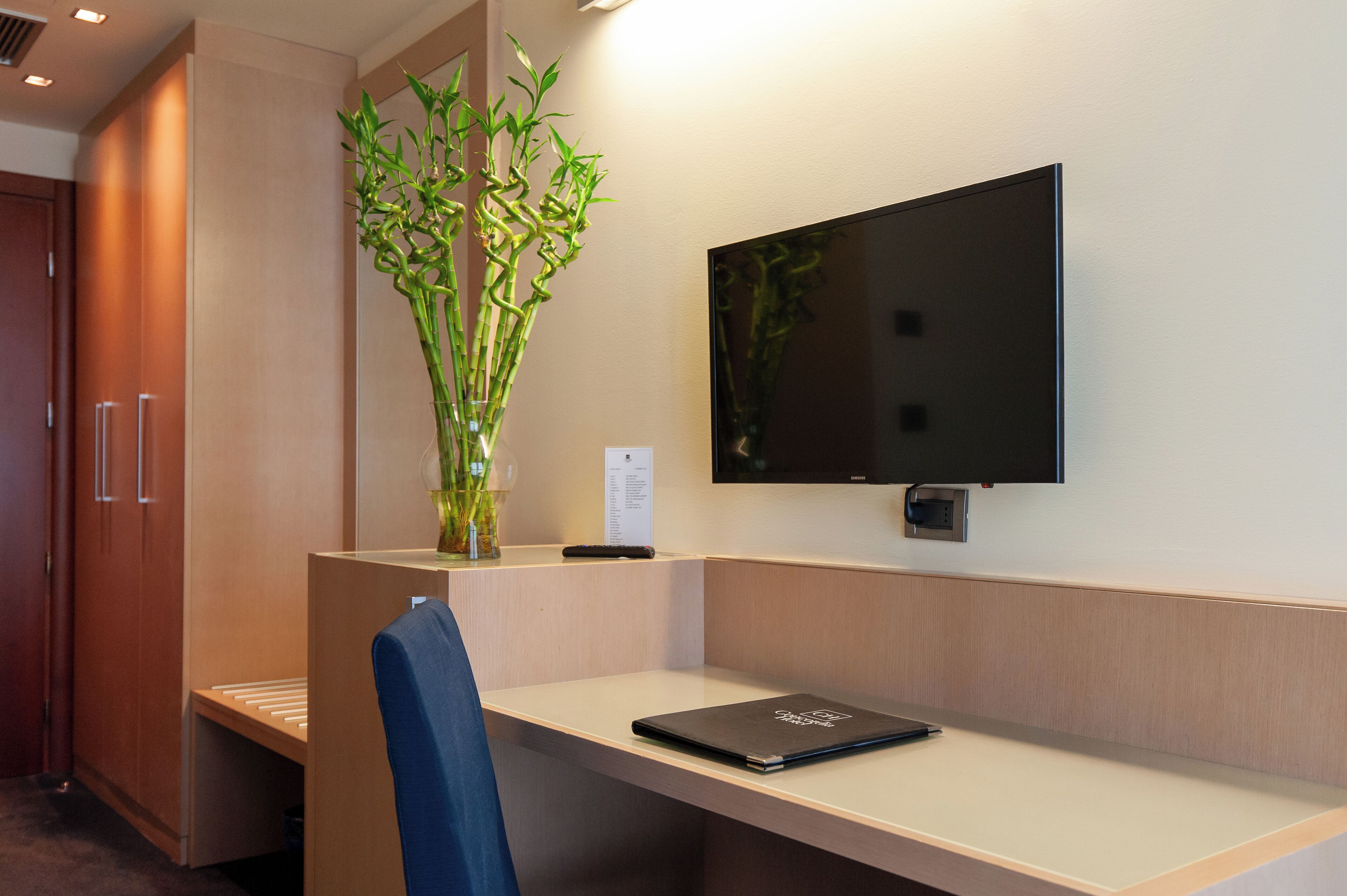 Un ufficio moderno con una scrivania, una sedia e un monitor di grandi dimensioni.