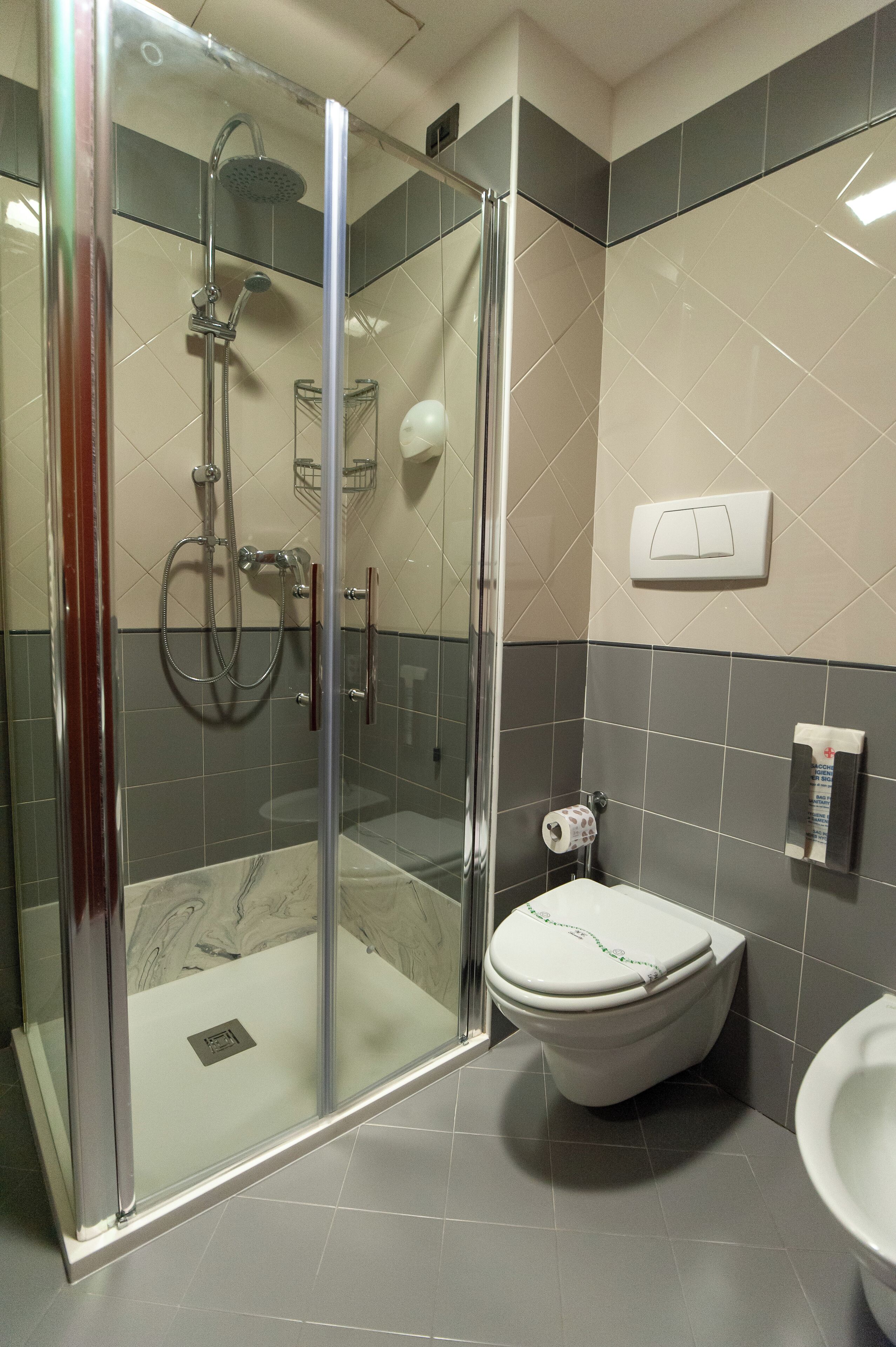 Un baño moderno con ducha de vidrio, inodoro y lavamanos.