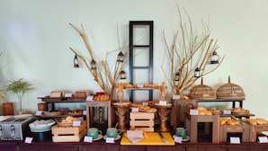 Montaje de bufé con diversos alimentos y elementos decorativos como ramas y faroles.