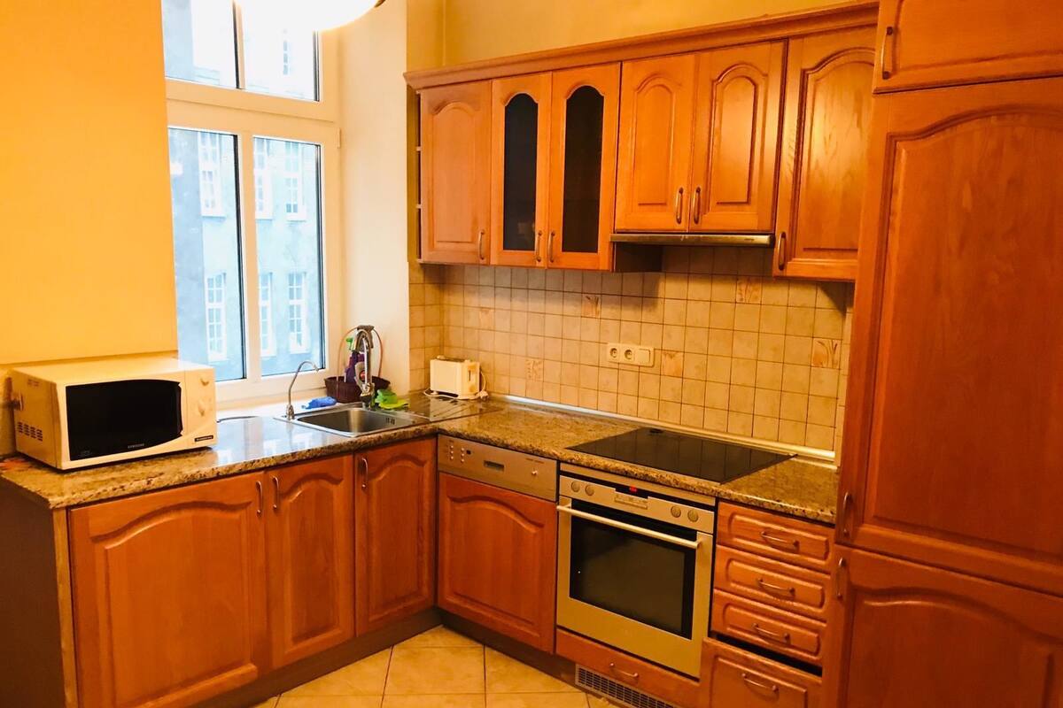 A kitchen with wooden cabinets, a microwave, a toaster, and a stove.