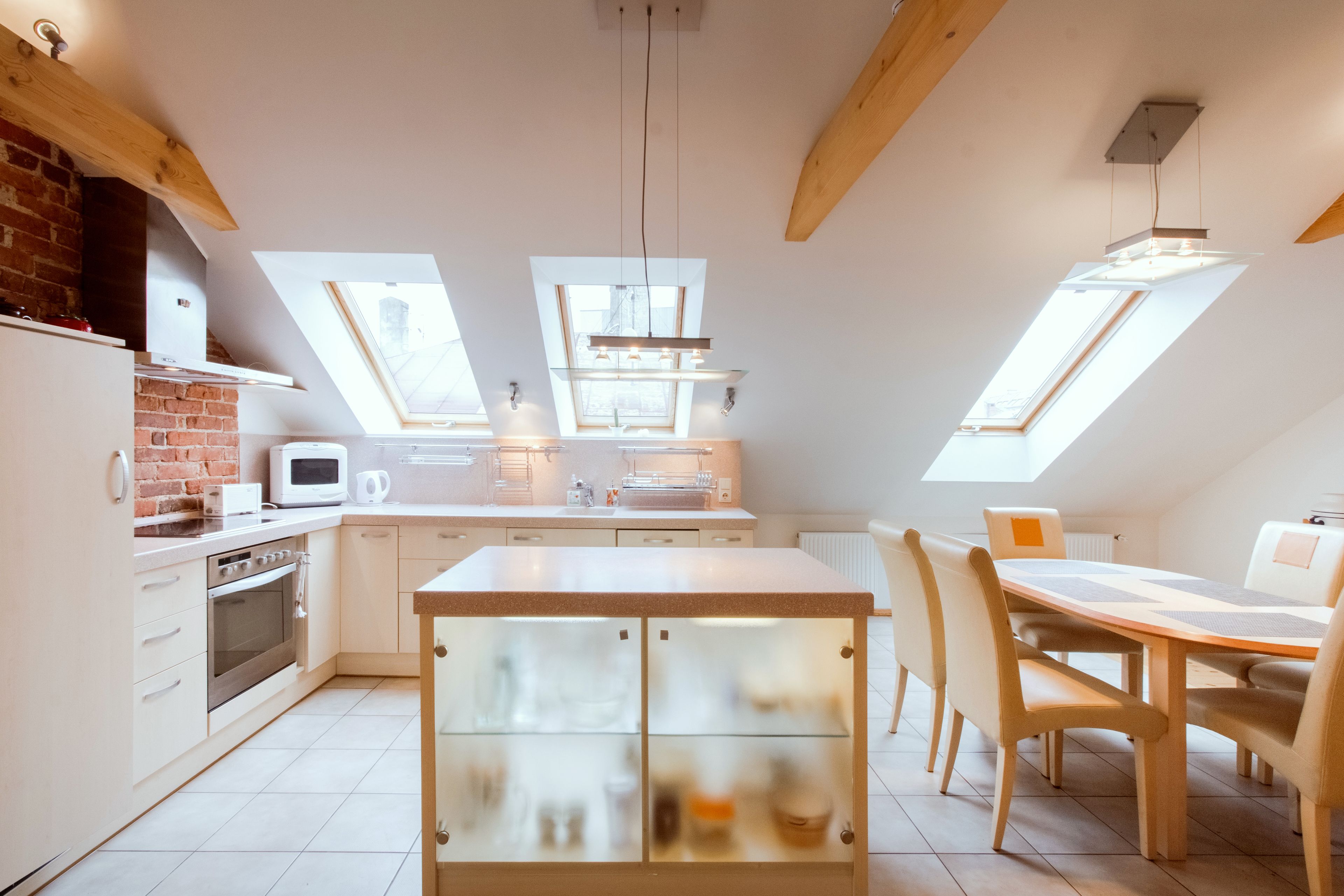 Una cucina moderna con lucernari, una zona pranzo con tavolo e sedie e un forno integrato.