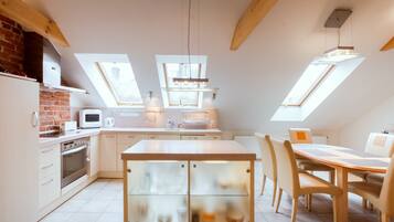 Una cucina moderna con lucernari, una zona pranzo con tavolo e sedie e un forno integrato.
