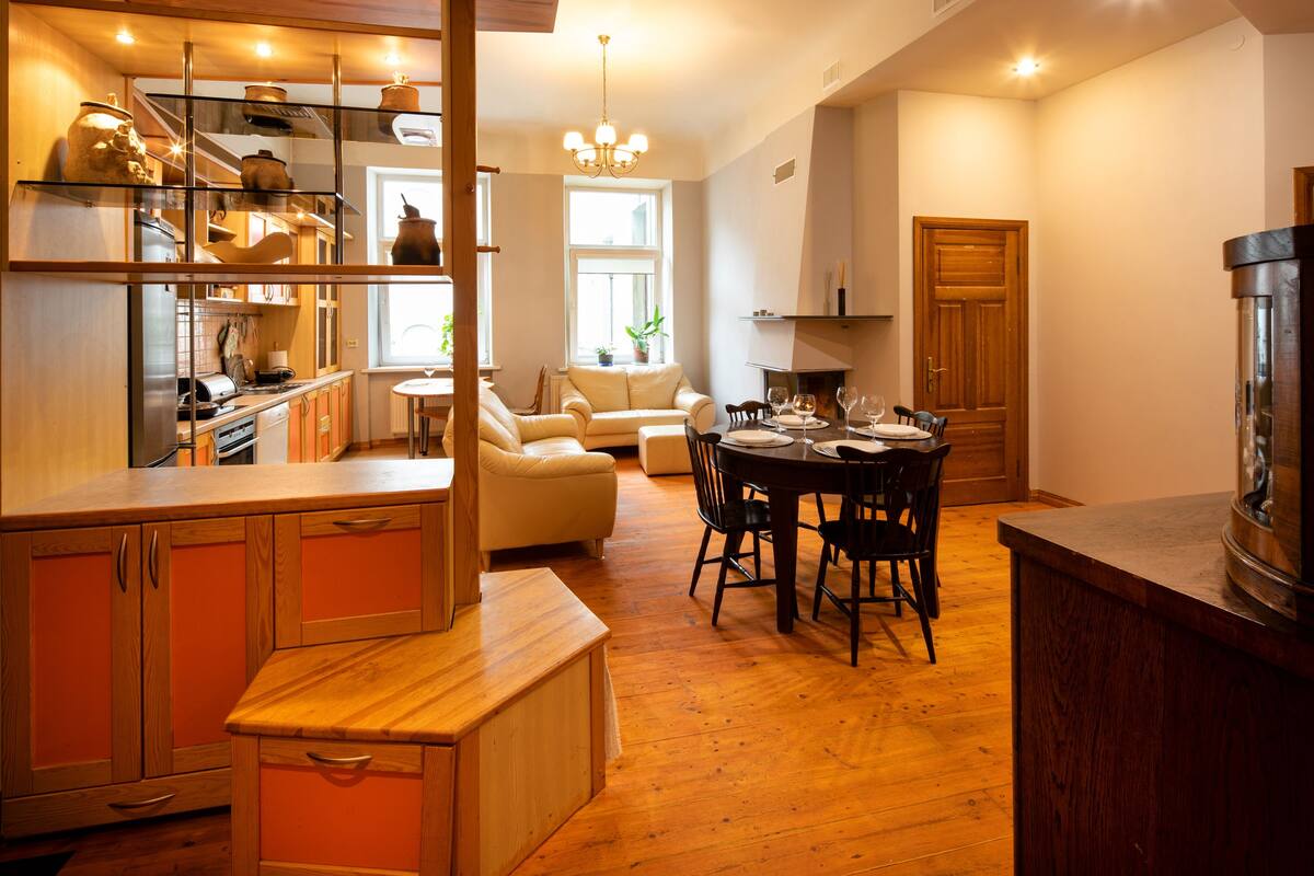 A kitchen with wooden cabinets and a dining area with a table and chairs.