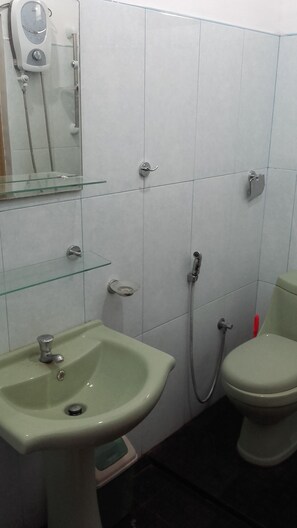 A bathroom with a sink, toilet, and shower.