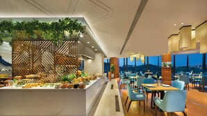 A modern dining area with a central buffet, wooden paneling, and a view of the cityscape. - Somerset Baitang Suzhou (Suzhou)