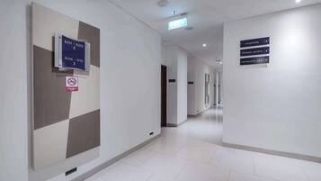 A clean, modern hallway with directional signs for room numbers and a non-smoking floor sign.