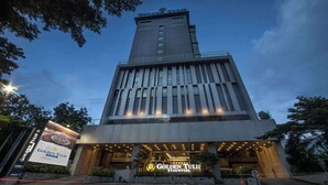 A modern hotel building with a prominent sign reading "Golden Tulip Essential." - Golden Tulip Essential Makassar (Makassar)