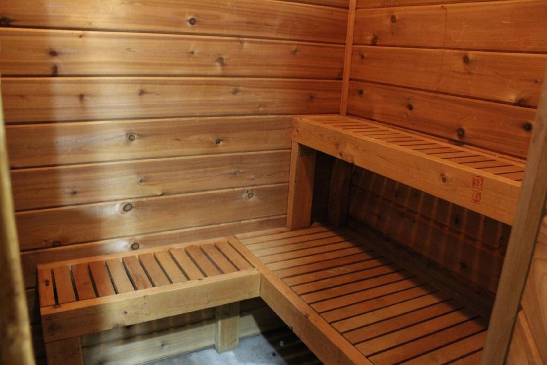 Eine Holzsauna mit Bänken und einer Sitzbank.